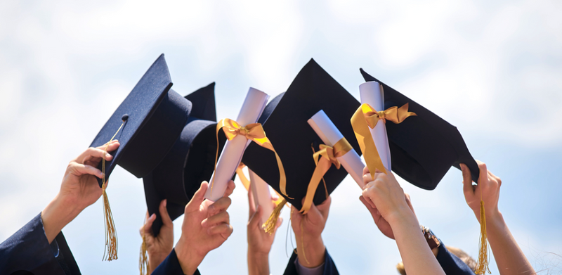 heads hold graduation hat