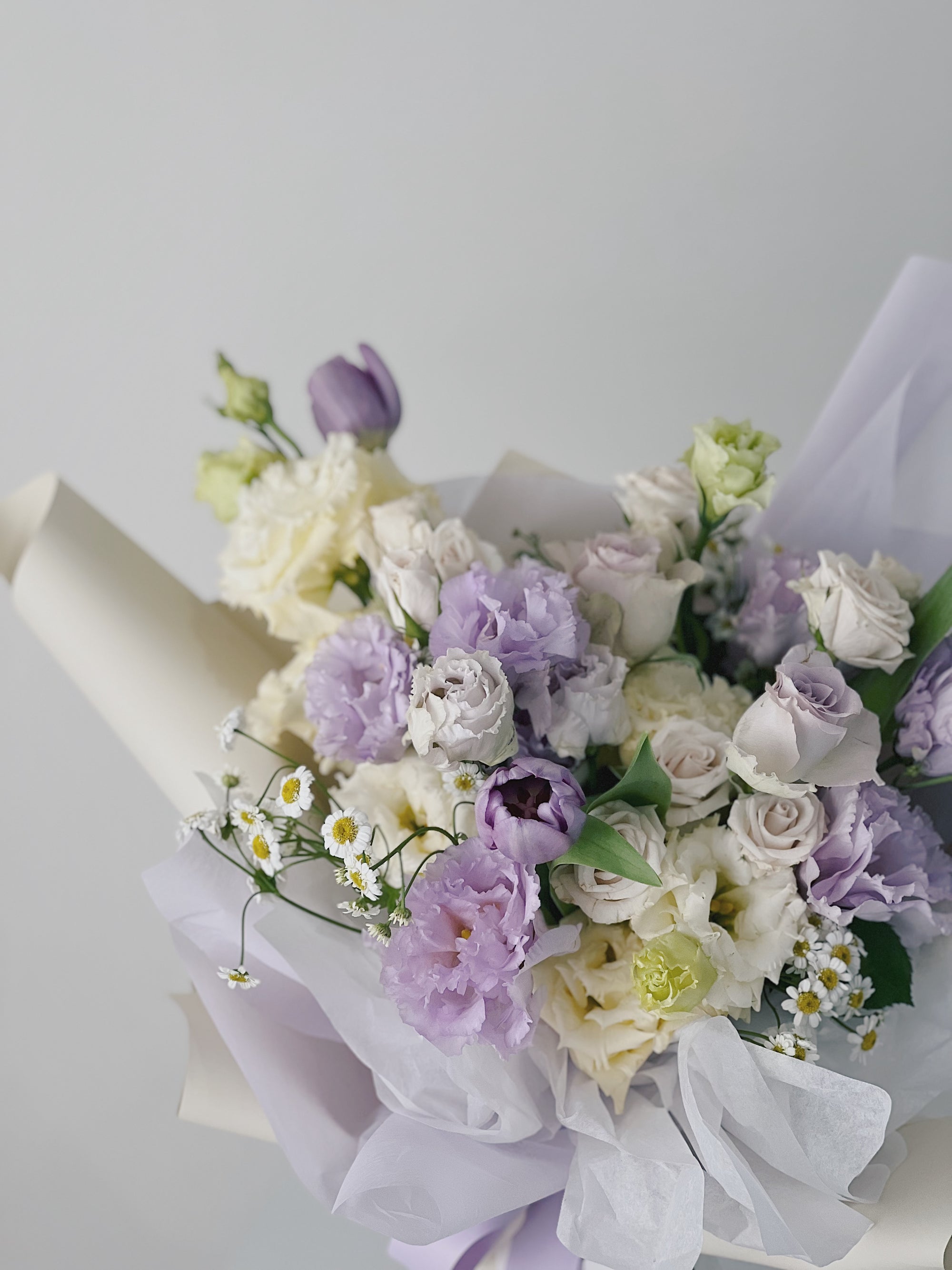 紫色和白色花朵組成的花束,綴有白色小花。