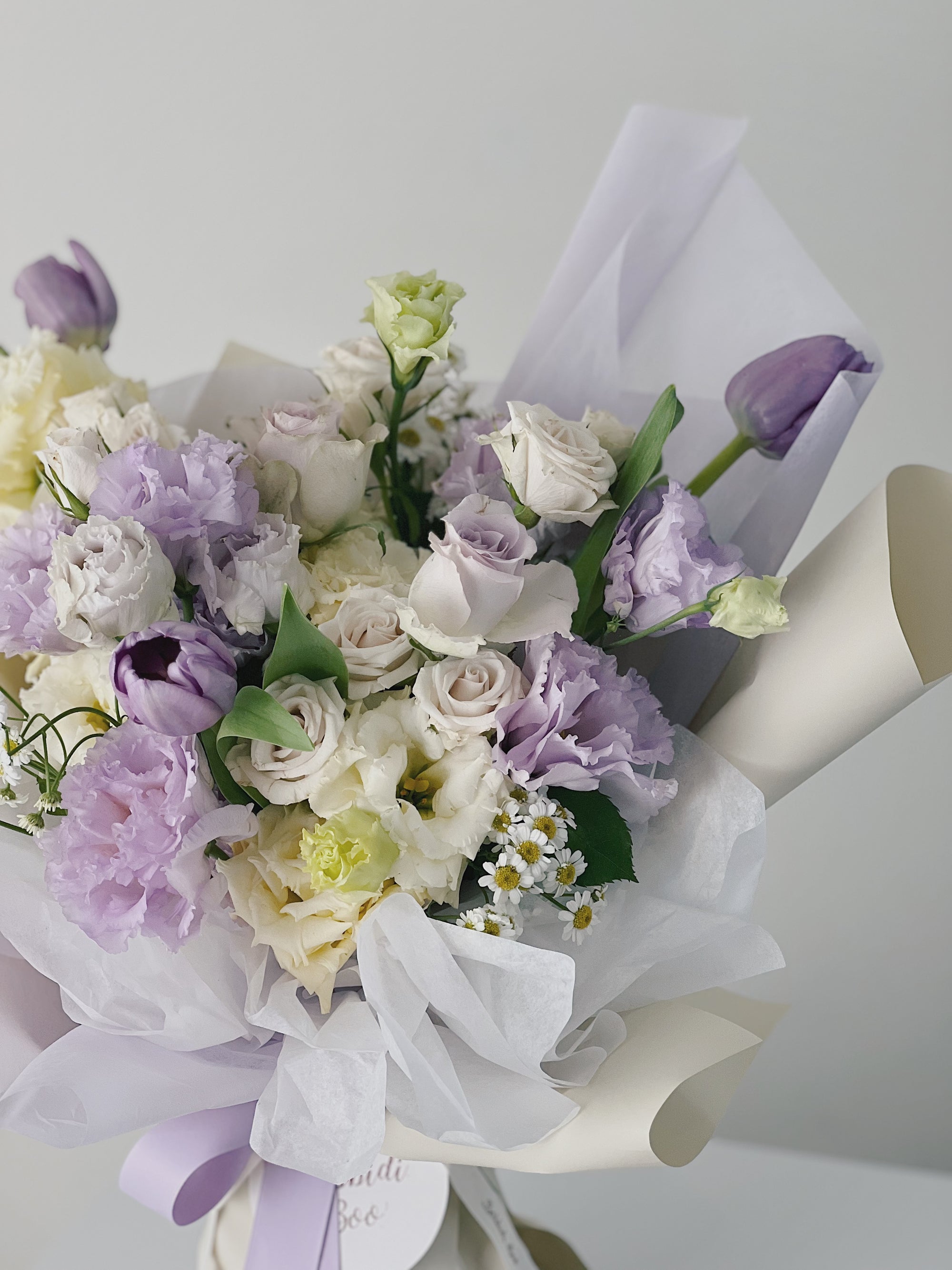 紫色與白色花朵組成的花束,包裝精美。