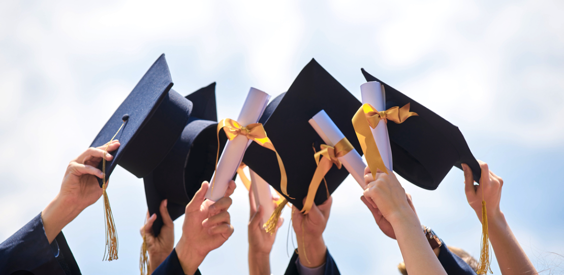 heads hold graduation hat