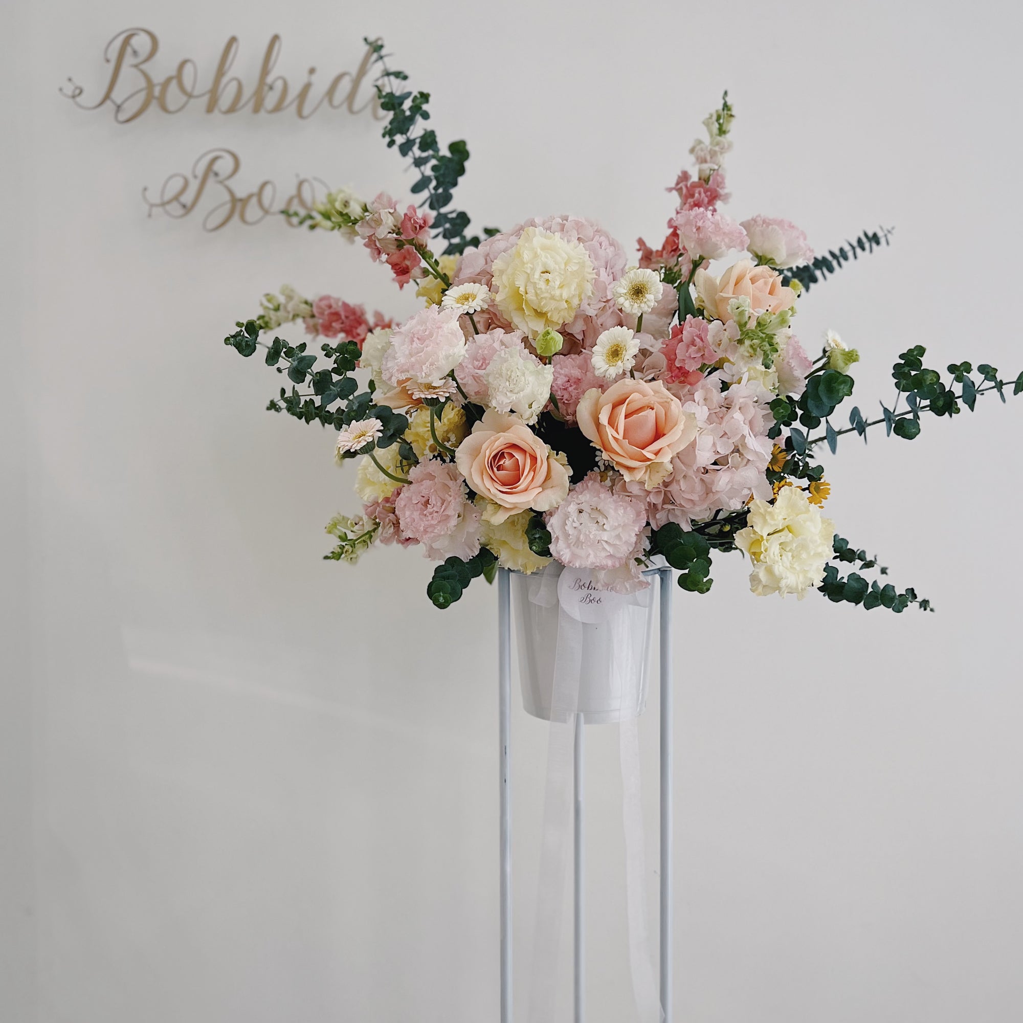 Elegant opening floral arrangement with pastel-colored roses and greenery.