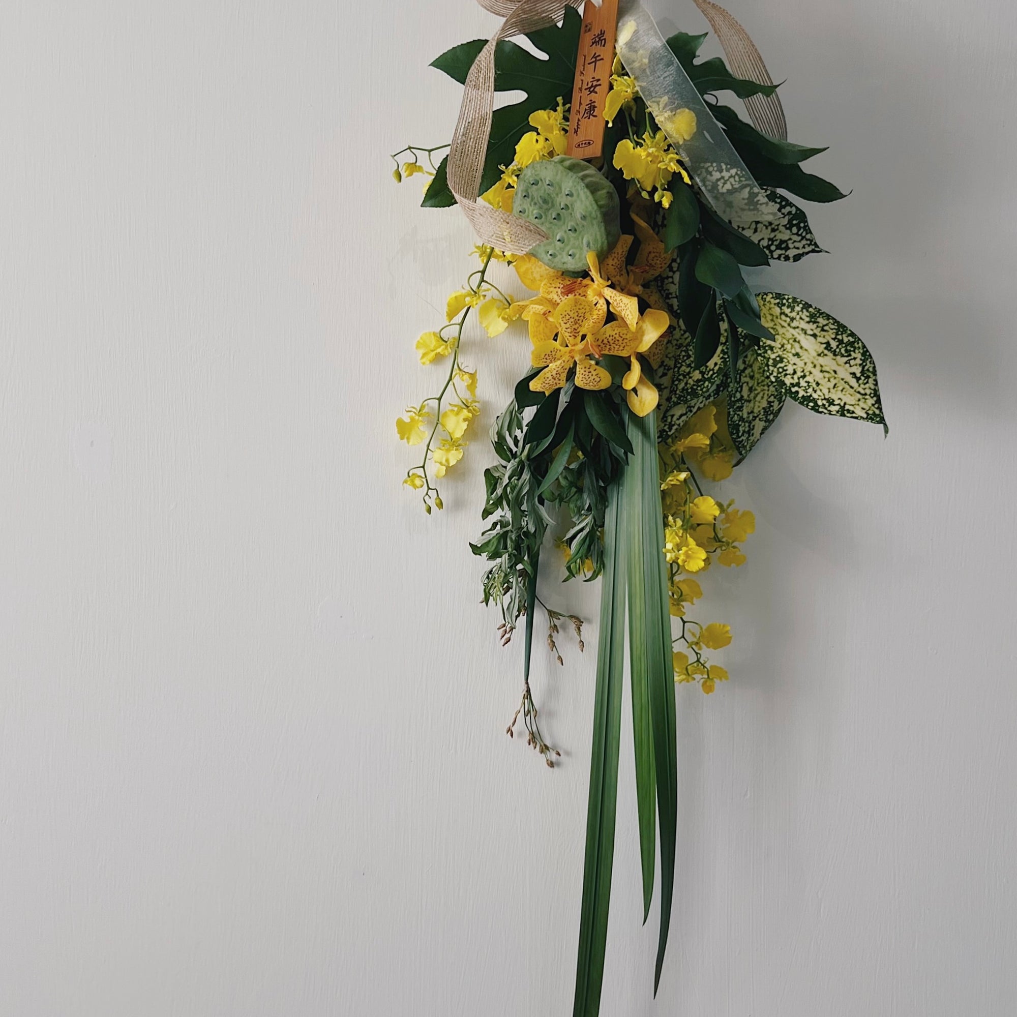 端午節艾草花束，綴有黃色花朵和葉子，配有絲帶蝴蝶結。