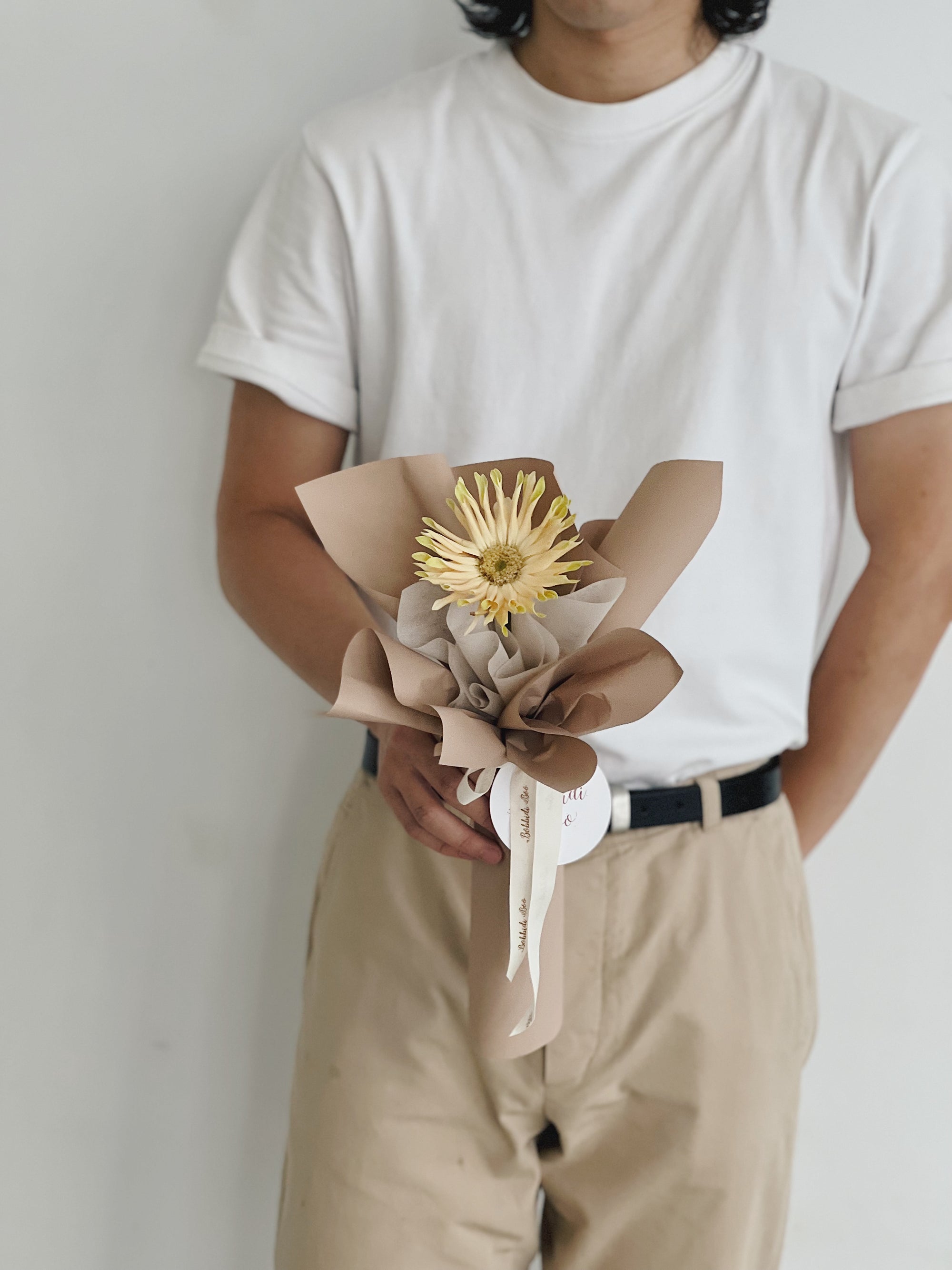 男子持單枝包裝太陽花花束。