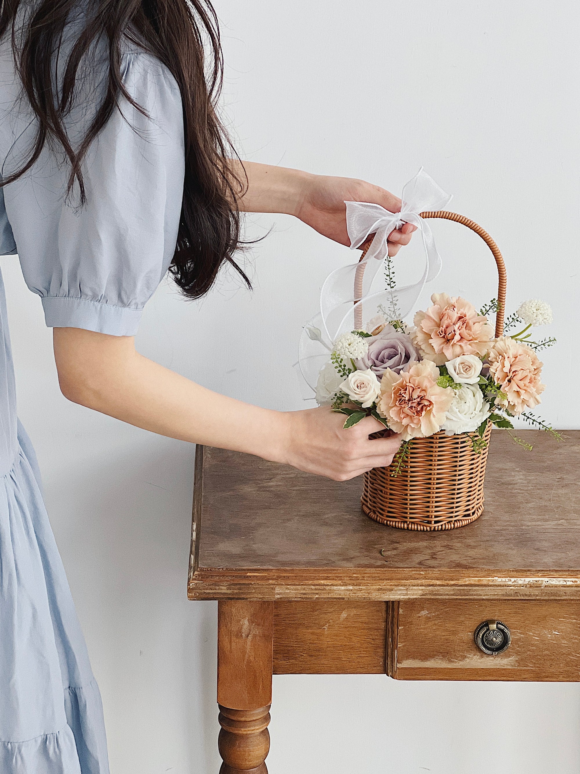 女人擺放盆花康乃馨在桌上。