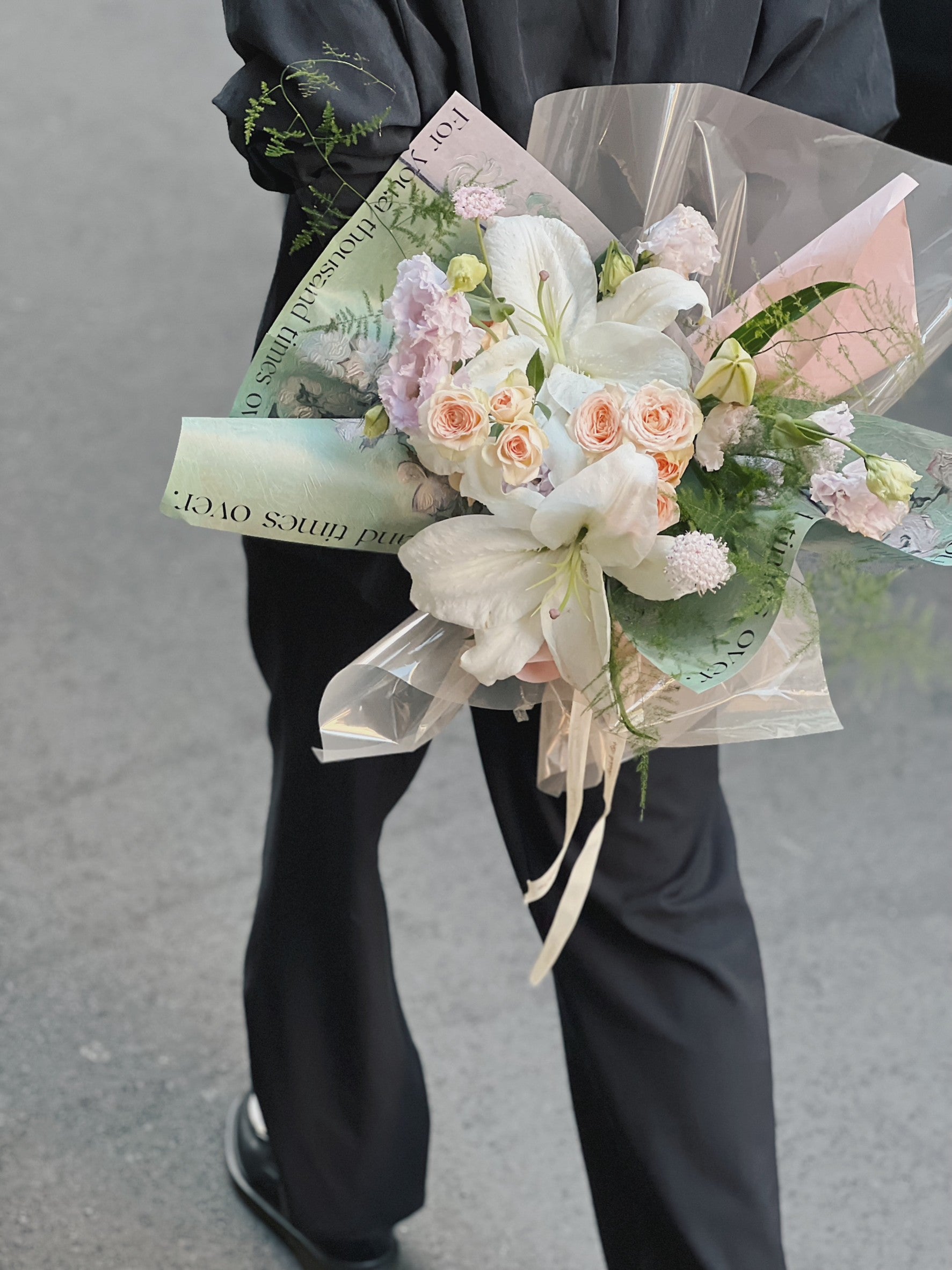 一束綠色包裝的百合花花束。