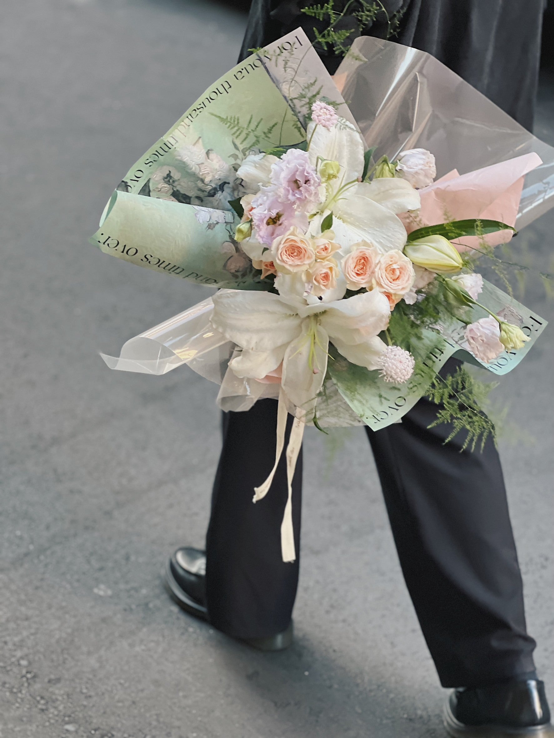 一束綠色包裝的百合花花束。