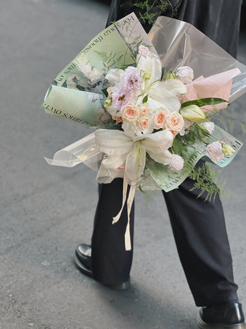 一束綠色包裝的百合花花束。