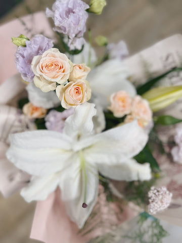 百年好合百合花花束，粉色包裝，包含白色百合與粉色玫瑰。
